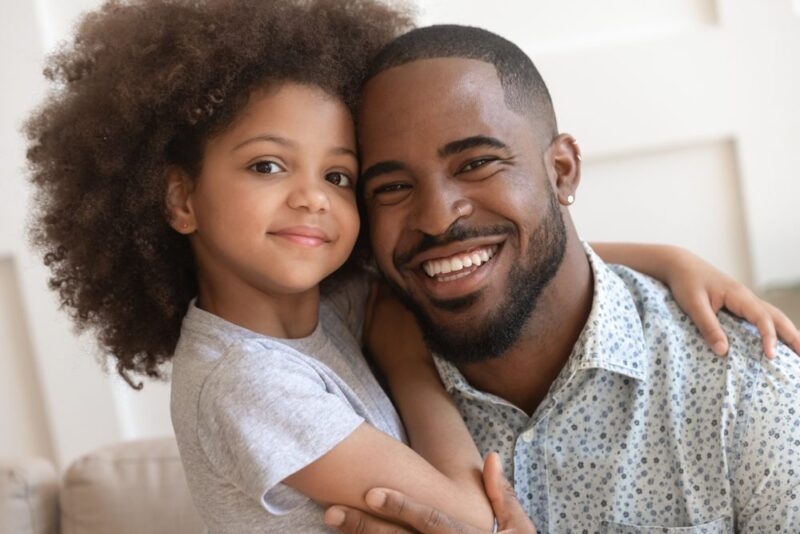 Smiling father and daughter posing cheek to cheek