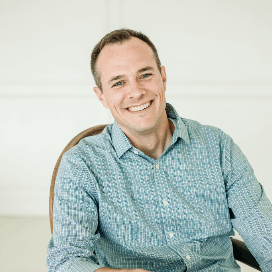 Dr. Justin Nylander smiling, seated in a blue checked shirt